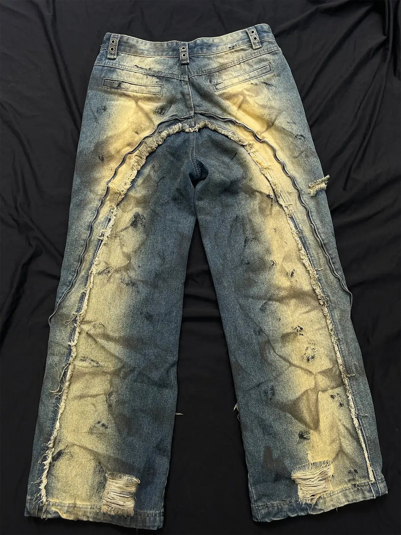 Distressed cargo jeans with artistic ripped design, showcasing heavy wear and a vintage washed finish.