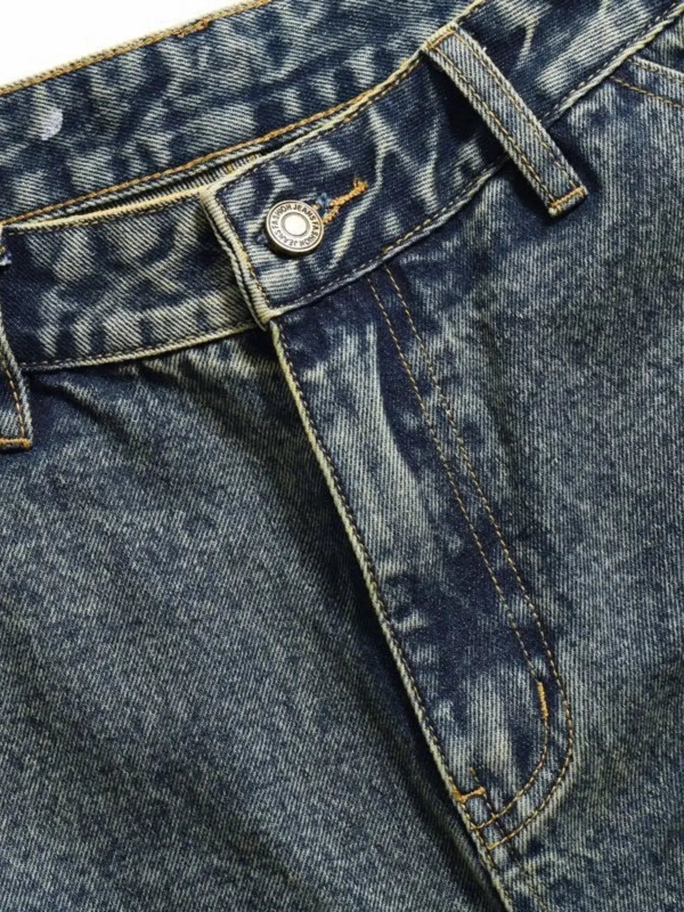 Close-up of vintage distressed multi-pocket cargo jeans showing the zipper and button detail.